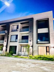 a large white building with windows on a street at Studio 19 Diamond-2bedroom apartment in Gaborone +54 photos