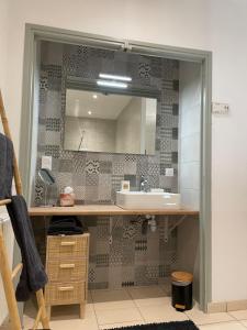 a bathroom with a sink and a mirror at Maison Côté Halle "La chambre du Parc" in Saint-Flour