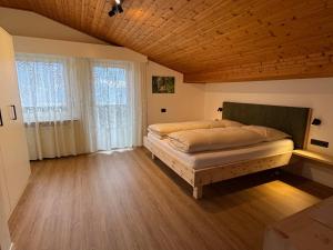 a bedroom with a bed and a wooden ceiling at Klostergut in Kastelbell-Tschars