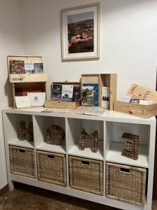 a white shelf with baskets and boxes on it at Casa Margherita (Alba) in Alba