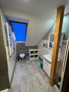 a attic bathroom with a sink and a toilet at Apartament nad jeziorem in Wilkasy +30 photos