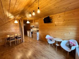 a room with a wooden wall with a table and chairs at Apartament nad jeziorem in Wilkasy