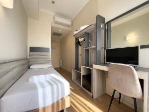una camera da letto con un letto e una scrivania con una TV di Hotel Laura a Roma