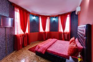 a red bedroom with red curtains and a bed at Marton Lion Krasnodar in Krasnodar