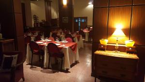 uma sala de jantar com mesas e cadeiras e um candeeiro em Montecassino em Capilla del Monte