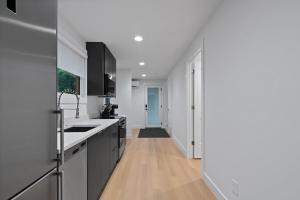 a kitchen with black and white cabinets and a hallway at Modern cabin #1 Close to town in Highlands