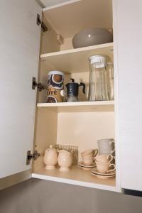 a cupboard filled with lots of cups and saucers at Appartamento Alpino Cles in Cles +32 photos