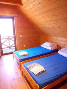 a bedroom with two beds in a log cabin at Słoneczna Chata dom Kasina Wielka in Kasina Wielka