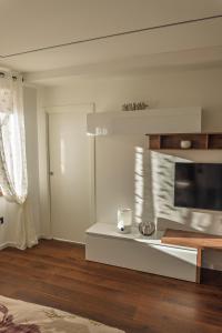 a living room with a television and a table at Appartamento Alpino Cles in Cles