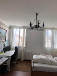 een slaapkamer met een bed en een bureau met een computer bij Proximité Palais des Festivals in Cannes