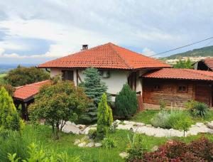 a house with an orange tiled roof in a garden at Etno kompleks Orahovac - Vila Paun in Vrbica