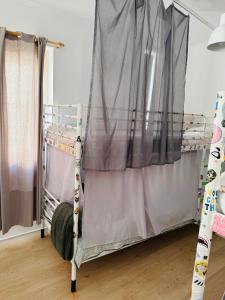 a bunk bed in a room with a curtain at 70's Hostel in Ericeira