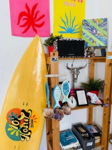a surfboard hanging on a wall next to a shelf at 70's Hostel in Ericeira