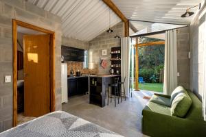a kitchen and living room with a green couch at Cabana para casal no Vale do Cuiabá Itaipava in Araras Petropolis