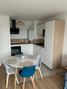 a kitchen with a table and chairs and a refrigerator at Azur in Camiers +7 photos