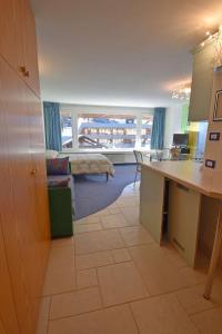 Una cocina y una sala de estar con una mesa y un sofá. en RAINALTER Studio 14A Centrale, en Madonna di Campiglio