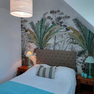 ein Schlafzimmer mit einem Bett und einer Wand mit Pflanzen in der Unterkunft Maison spacieuse avec piscine in Guidel