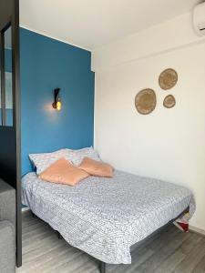 圣普里安海滩Grand Studio avec Balcon au pied de la Plage Clim Wifi的卧室里有一张床，墙壁是蓝色的 更多13张照片