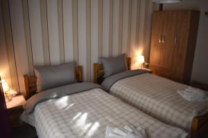 two beds in a small room with two lamps at Floor in Alexandroupoli