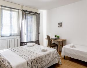 ヴェネツィアにあるCharming Two Bedroom Private Apartmentのベッド2台とテーブルと窓のある寝室