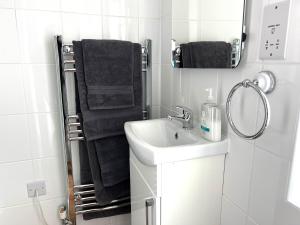 a white bathroom with a sink and a mirror at Large Family-Friendly 2BD Glastonbury Retreat, Sleeps 5 in Glastonbury +24 photos