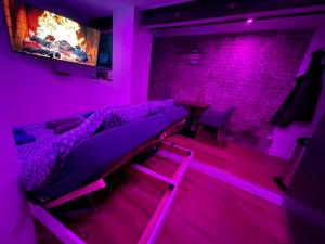 una camera con letto e camino con luci rosa di Nuit magique jacuzzi, terrasse & lit motorisé - 008 a Rouen