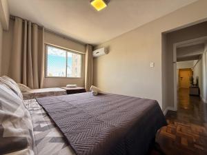 Ένα ή περισσότερα κρεβάτια σε δωμάτιο στο IZ01- Pé na Areia| Centro| Completo| Garagem