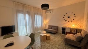 a living room with a table and a clock on the wall at Green House Calolziocorte in Calolziocorte
