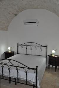 a bedroom with a black bed with two night tables at Masseria Costanza in Putignano