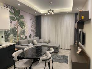 a living room with a couch and a table and chairs at Sol Garden Residence F16 in Alanya