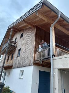 a man and woman standing on a balcony of a building at ChiemseeRefugium - Ferienwohnung Berg in Bernau am Chiemsee