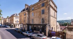 a building with cars parked on the side of a street at Vintner Townhouse Artisan Quarter Bath in Bath