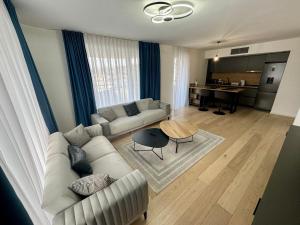 サラエボにあるLux Sarajevo Waves 2bdr apartment with private parkingのソファとテーブルのあるリビングルーム