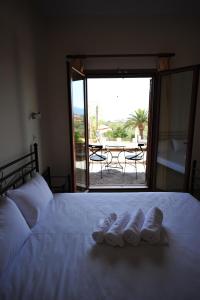 a bedroom with a bed with two pairs of shoes on it at Casa Gustosa Μονεμβασιά in Monemvasia