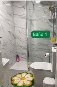 La salle de bains est pourvue d'une douche et de toilettes avec un tapis de fleurs. dans l'établissement La casa amarilla de Luis y Eileen, à La Vila Joiosa 36 autres photos