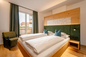 a bedroom with a large bed and a window at Arlbergerhof Vital in Weissensee