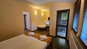 a bedroom with a large bed and a window at Hotel Izvorat Arda - Хотел Изворът Арда in Arda