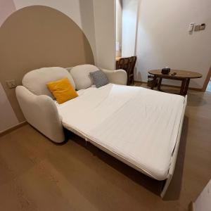 ナゴヤにあるCasabella Homestay 103 Batam Penuinの白いソファ付きの客室のベッド1台