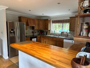 a kitchen with wooden cabinets and a stainless steel refrigerator at Seacroft in Kirkton