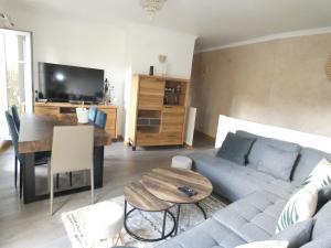 a living room with a couch and a table at Appartement spacieux et 5 minutes DISNEY LAND PARIS in Bailly-Romainvilliers