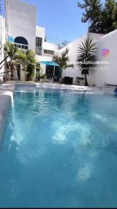 Una gran piscina azul frente a un edificio en Palmira Cuernavaca 8 people, heated pool, en Cuernavaca