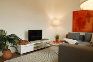 a living room with a couch and a flat screen tv at Engel Apartments in Hard