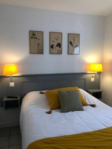 a bedroom with a bed with three pictures on the wall at Le Petit Bois in Sainte-Marie-de-Ré
