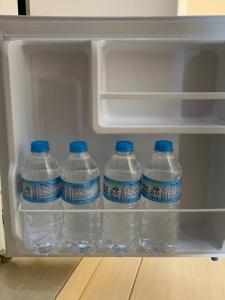a refrigerator full of water bottles with blue caps at Casal Suíte Privativa com Sacada in Sao Jose do Rio Preto +3 photos