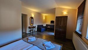 a bedroom with a bed and a living room at Hotel Izvorat Arda - Хотел Изворът Арда in Arda
