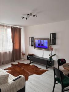 a living room with a flat screen tv on a wall at City Comfort Apartment in Bacău