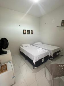 two beds in a room with white walls at Meu apartamento preferido in Tianguá