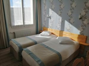 Postel nebo postele na pokoji v ubytování Hôtel Les Fleurs