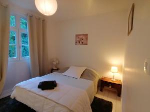 a bedroom with a bed with a black bag on it at Les Vignes du Château Duras Wifi et Belle vue in Duras +5 photos