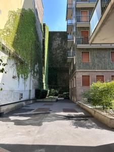 an alley between two buildings with ivy on the side at House Crocetta in Milan +33 photos